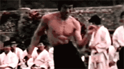 Shirtless Man Standing In Front Of Group GIF