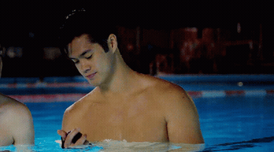 Shirtless Man Standing In Swimming Pool At Night GIF