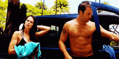 Shirtless Man Standing Next To Woman In Bikini GIF