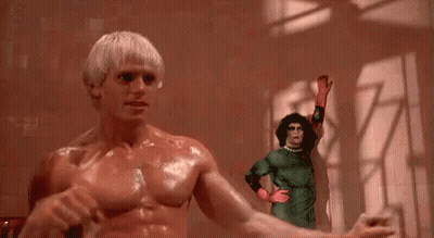 Shirtless Man Standing Next To Woman In Green Costume GIF
