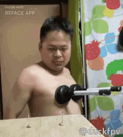 Shirtless Man Using Dumbbell On Wooden Table GIF