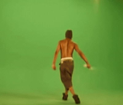 Shirtless Man Walking On Green Screen Holding Stick GIF