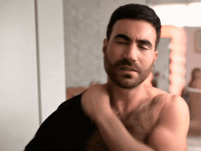 Shirtless Man With Beard Adjusting Shirt GIF