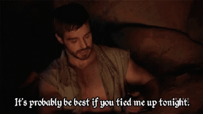 Shirtless Man With Beard Sitting In Dark Room GIF