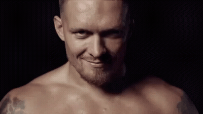 Shirtless Man With Beard Smiling In Dark Room GIF