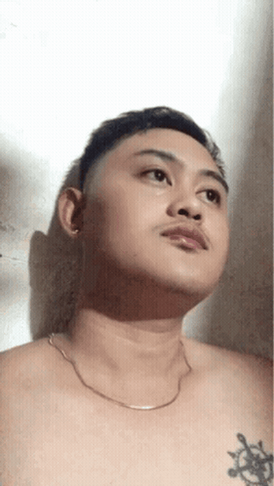 Shirtless Man With Chest Tattoo And Chain Looking Up GIF