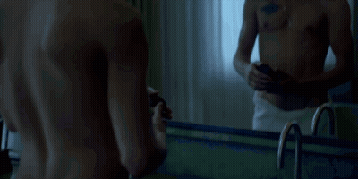 Shirtless Man With Chest Tattoo Looking At Phone GIF