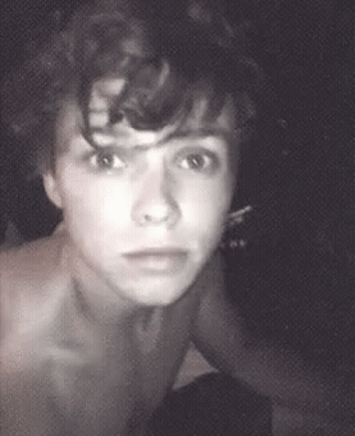 Shirtless Man With Curly Hair Looking At Camera GIF