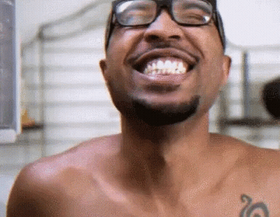 Shirtless Man With Glasses And Tattoo Smiling GIF