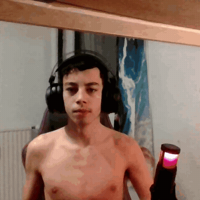 Shirtless Man With Headphones Holding Red Light GIF