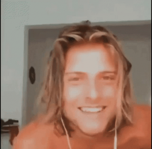 Shirtless Man With Long Hair Smiling And Wearing Earbuds GIF