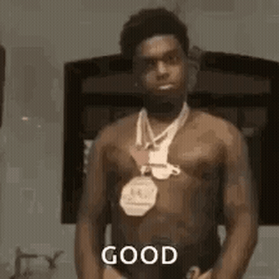 Shirtless Man With Medal Before Mirror GIF