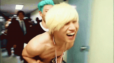 Shirtless Man With Medal Laughing With Another Man GIF