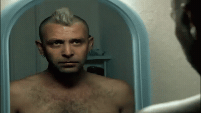 Shirtless Man With Mohawk Looking At Mirror GIF