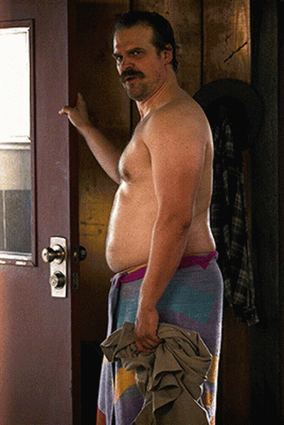 Shirtless Man With Mustache Holding Towel In Doorway GIF