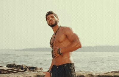 Shirtless Man With Necklace And Bracelets On Beach GIF