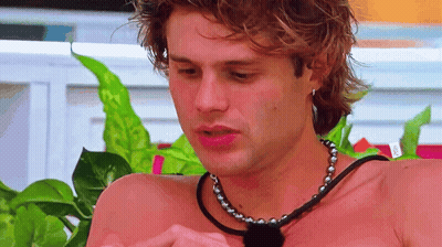 Shirtless Man With Necklace Looking Down GIF