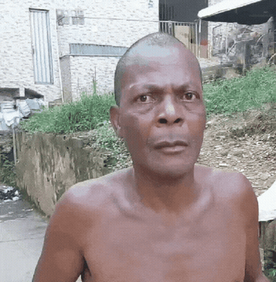 Shirtless Man With Shaved Head Looking At Camera GIF