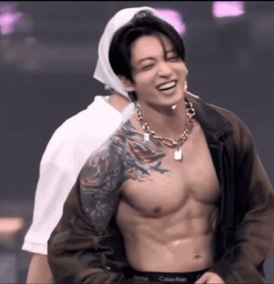 Shirtless Man With Tattoo Smiling Beside Another GIF