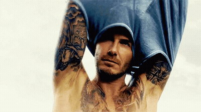 Shirtless Man With Tattoos Holding Shirt Over Head GIF
