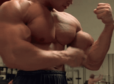 Shirtless Muscular Man Flexing in Gym