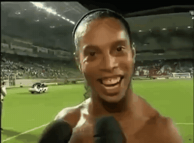Shirtless Soccer Player Smiling Talking Into Microphone GIF