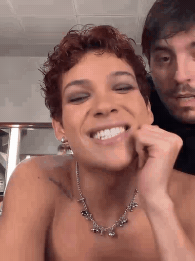 Shirtless Woman Smiling With Necklace And Earrings GIF