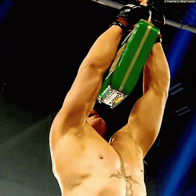 Shirtless Wrestler Hanging Upside Down Holding Green Belt Saying The Next Big Thing GIF