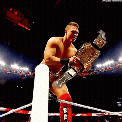 Shirtless Wrestler Holding Championship Belt GIF