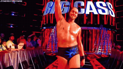 Shirtless Wrestler In Front Of Big Cass Sign GIF