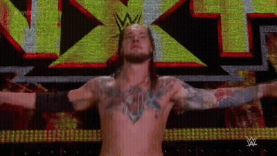 Shirtless Wrestler In Front Of Large X On Screen GIF