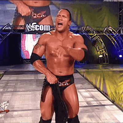 Shirtless Wrestler in Front of w.com Sign