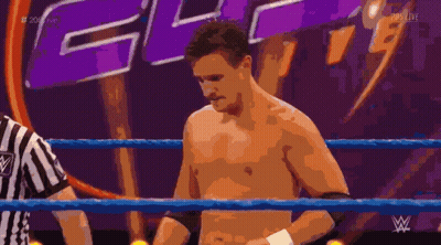 Shirtless Wrestler In Ring With Referee And WWE Logo GIF