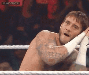 Shirtless Wrestler Sitting In Ring With Hands On Head GIF