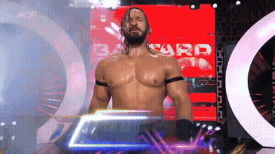 Shirtless Wrestler Standing In Front Of Bard Screen GIF