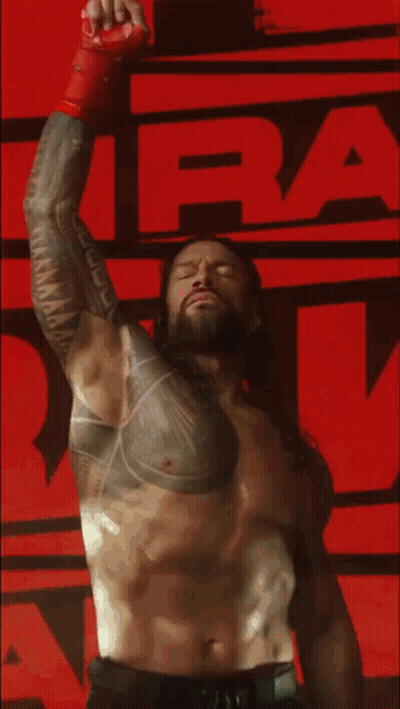 Shirtless Wrestler With Chest Tattoo Raising Arm GIF