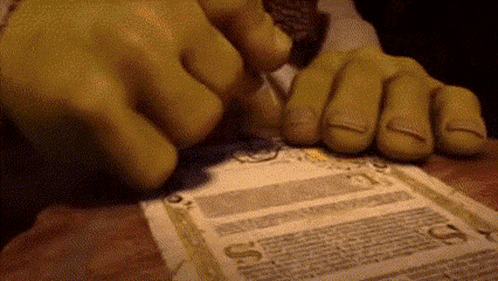 Shrek 'S Hands Are Holding A Piece Of Paper That Says ' A ' On It . GIF