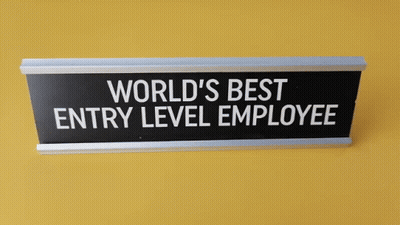 Sign On Yellow Wall Says World's Best Entry Level Employee GIF