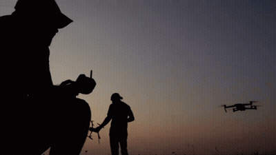Silhouette Man Holding Remote Control With Drone GIF