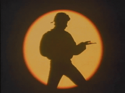 Silhouette Of Man Holding Gun By Circle Of Light GIF