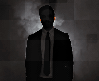 Silhouette Of Man In Suit And Tie In Dark Room GIF