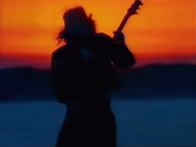 Silhouette Of Man Playing Guitar At Sunset GIF
