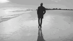 Silhouette Of Man Walking Away On Beach GIF