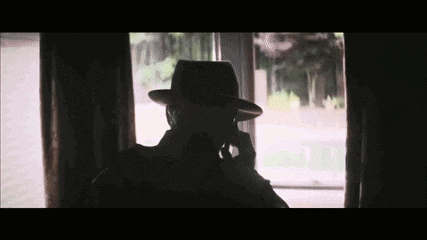 Silhouette Of Man Wearing Hat Talking On Cell Phone GIF