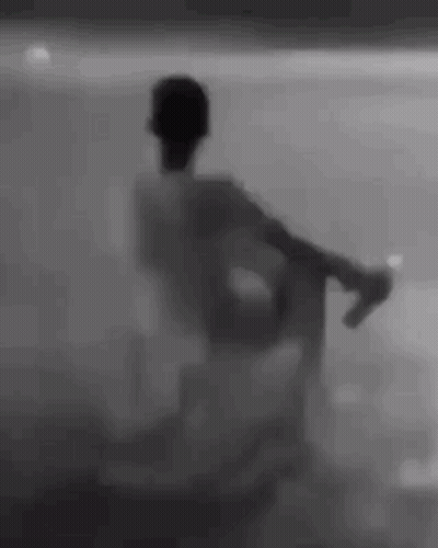 Silhouette Sitting In Chair Behind Glass Wall GIF