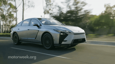 Silver Car Driving Down Road With Motorweek.org GIF
