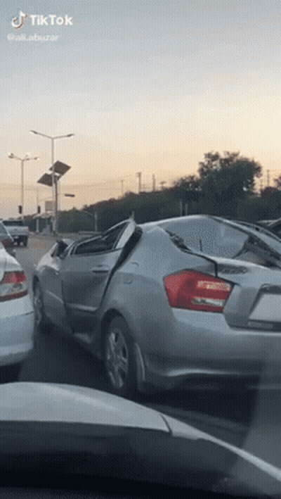 Silver Car With Broken Windshield Driving On Street GIF