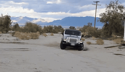 Silver Jeep Driving Through Sandy Area GIF
