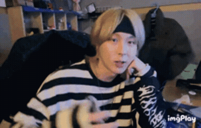 Sitting Man With Headband And Striped Sweater GIF
