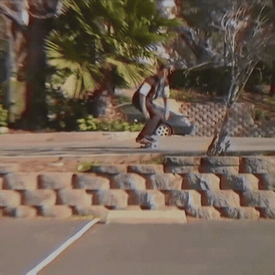 Skateboarder Doing Trick On Sidewalk GIF